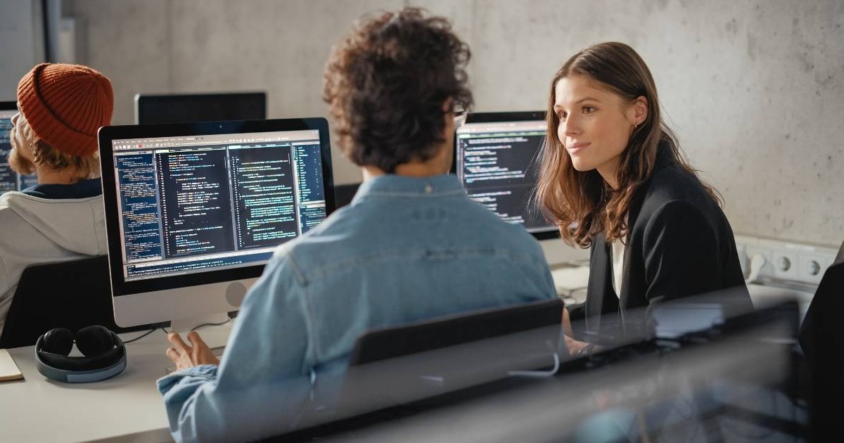 Young woman speaking to a male colleague